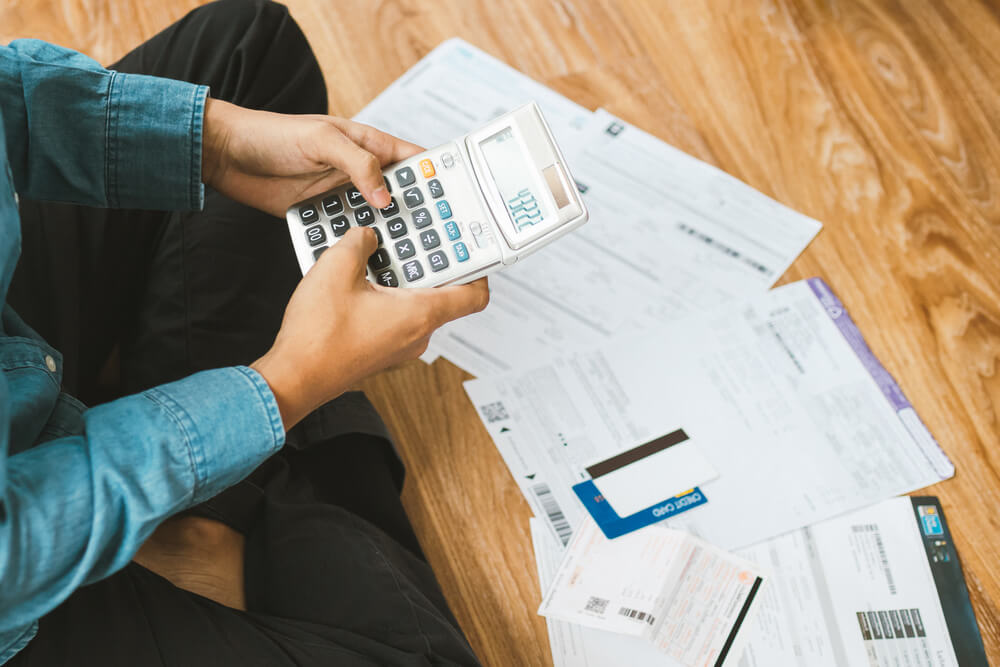 Top view man sitting on the floor stressed and confused by calculate expense from invoice or bill